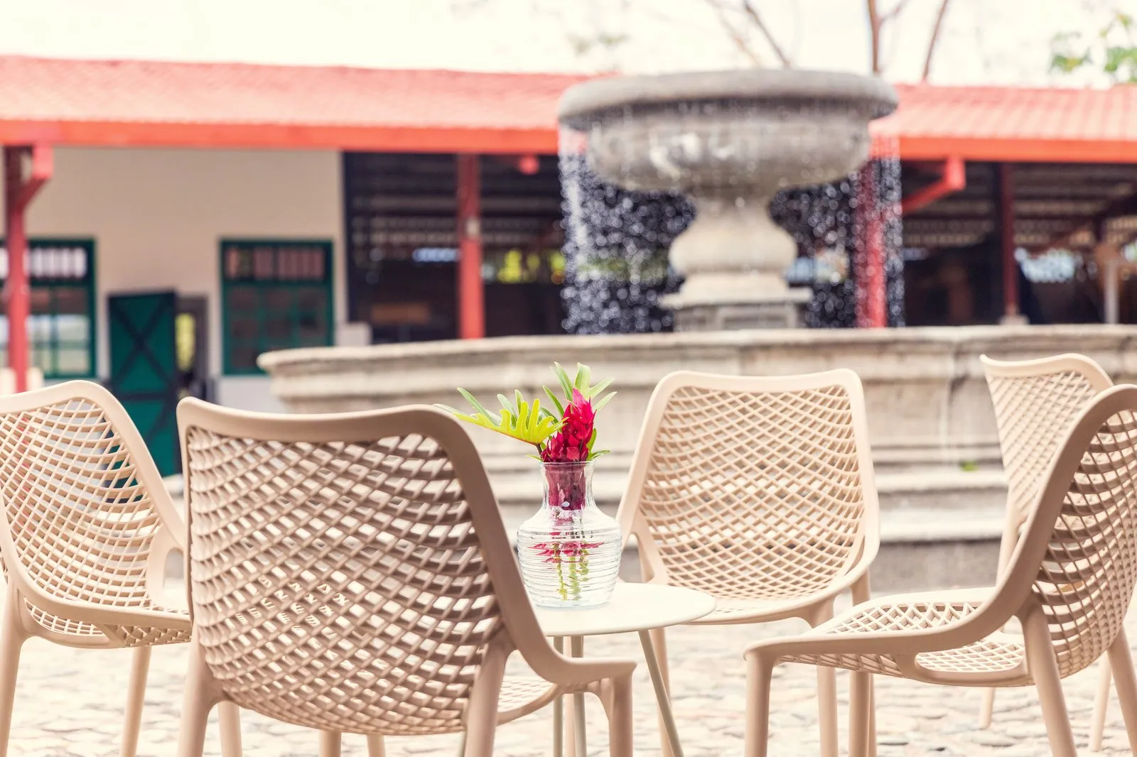 Café seating with tropical flowers and fountain at The Town Square, RISE Costa Rica